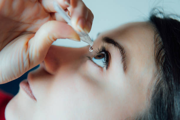 woman putting eye drops